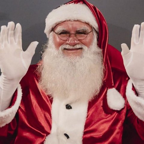 Papai Noel sorrindo com as mãos levantadas